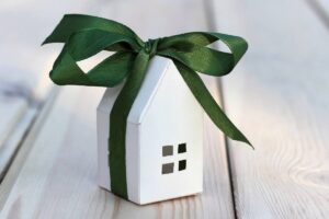 casetta in miniatura avvolta da un fiocco regalo