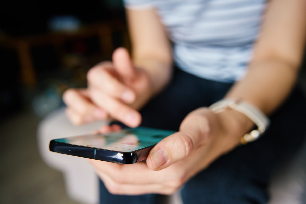 Adolescente che pubblica un post sui social con il suo smartphone