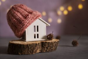 Modellino di casa con berretto di lana sopra