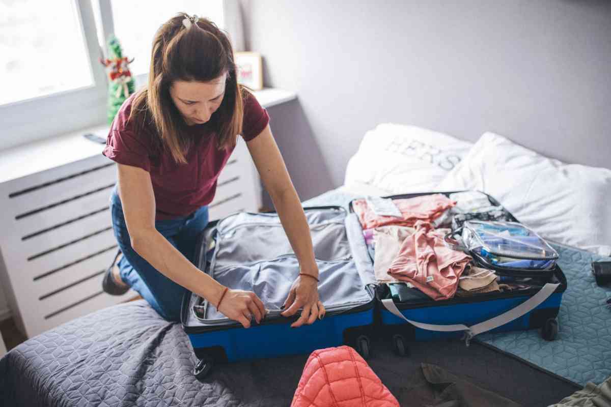 Donna che sistema le cose in valigia